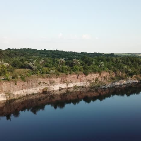 aerial view. flying over the quarry lake. beautiful view of the river landscape. rocky shoreline of the lake with forest.