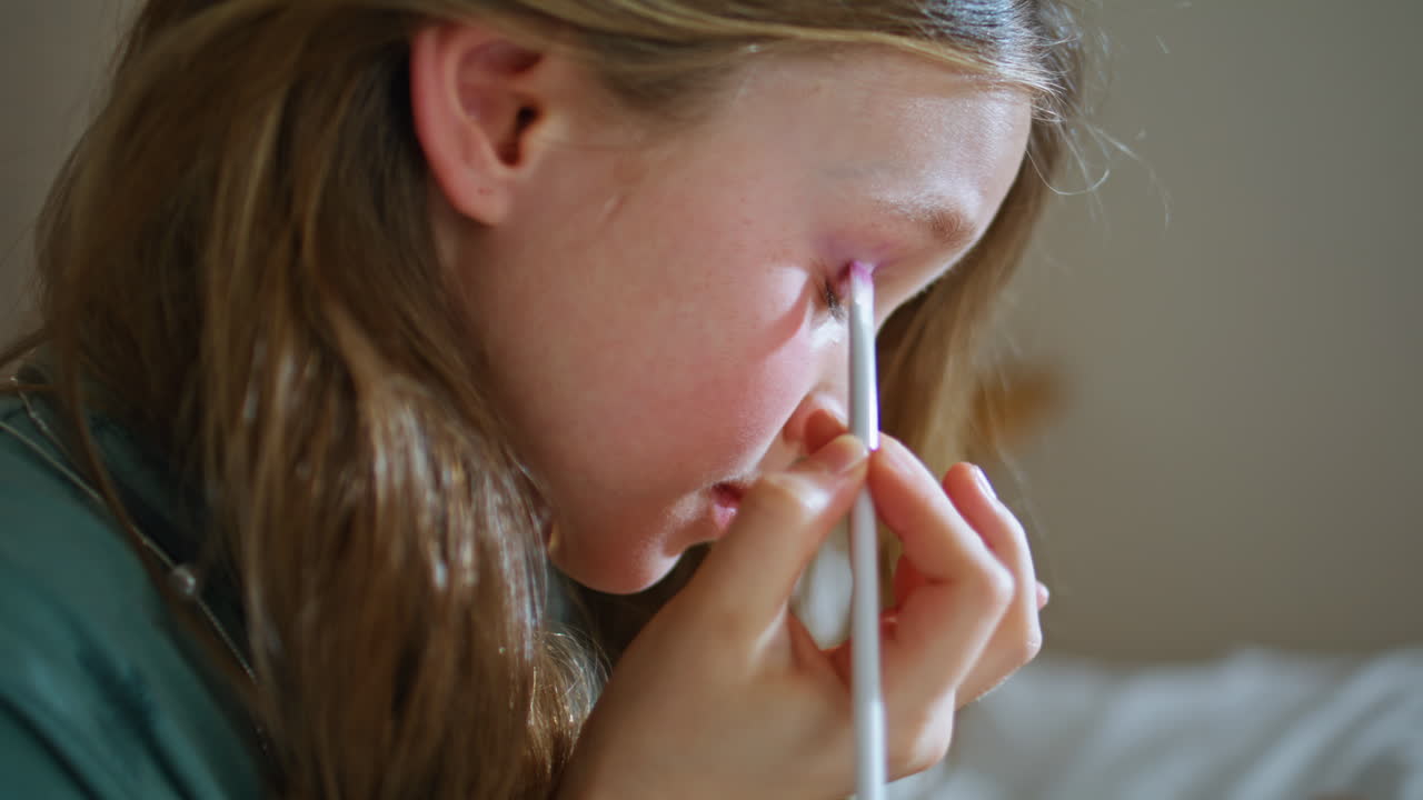 Little girl playing makeup with mothers cosmetics shadows at bedroom closeup