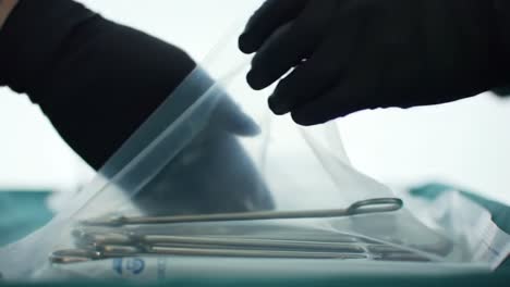 surgical preparation: a close-up examination of sterile instruments being handled in a clinical environment by a gloved hand