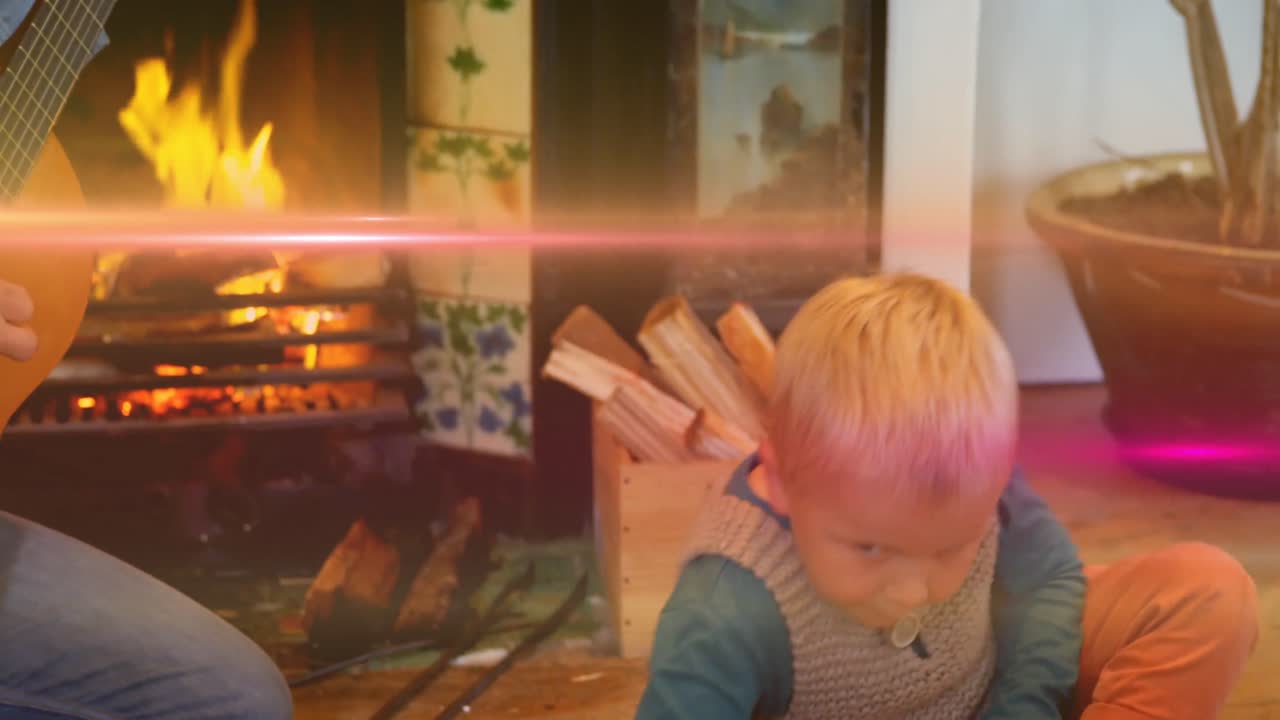 Animation of light flashing over caucasian father playing guitar and singing to son