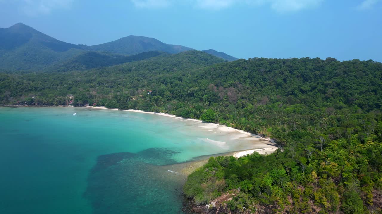 ong beach at koh chang island showing turquoise water and green rainforest in Trat Province, Thailand. Majestic aerial view flight descending drone