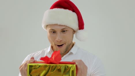 man in santa hat surprised by christmas gift