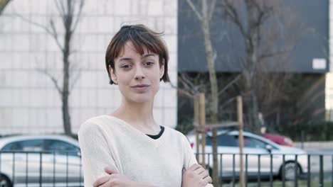 cheerful young lady with crossed arms standing on street