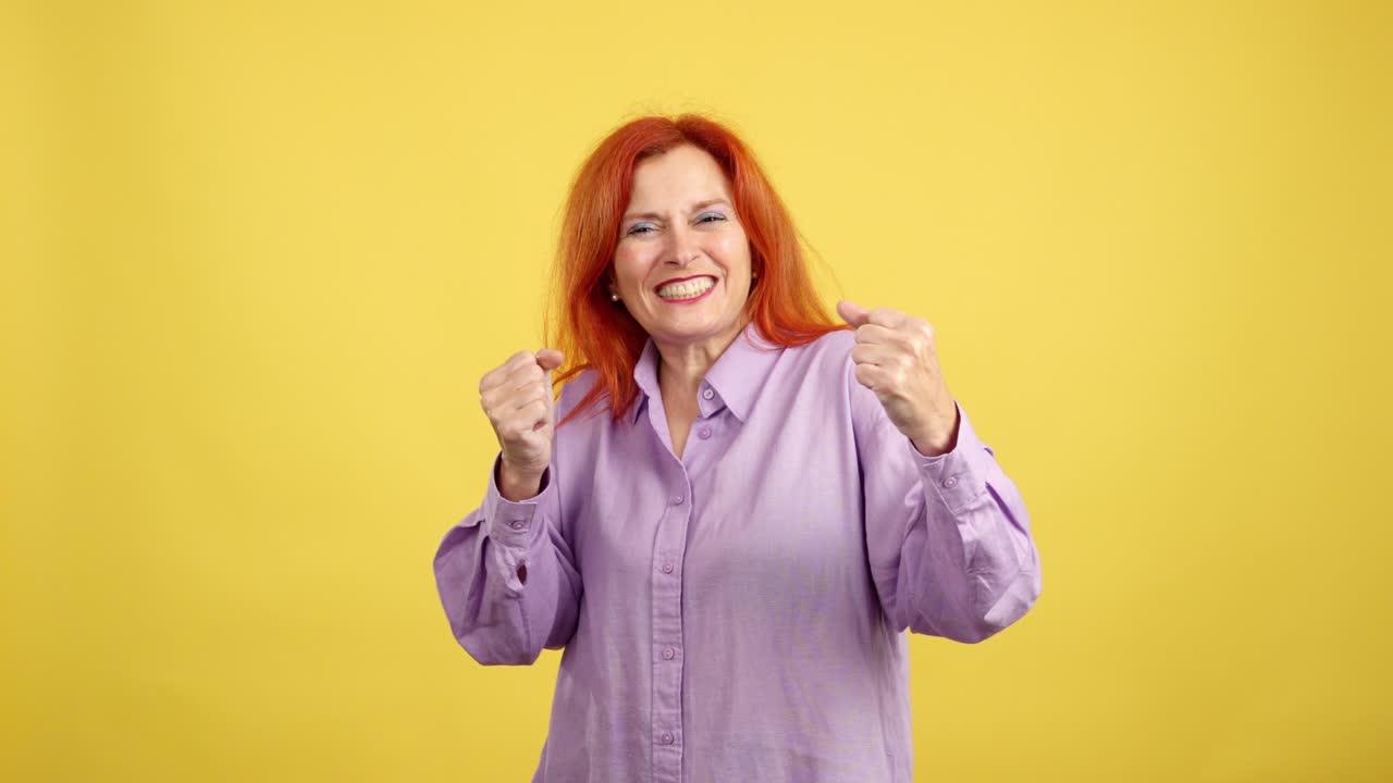 Excited woman celebrating success with various gestures on a yellow background