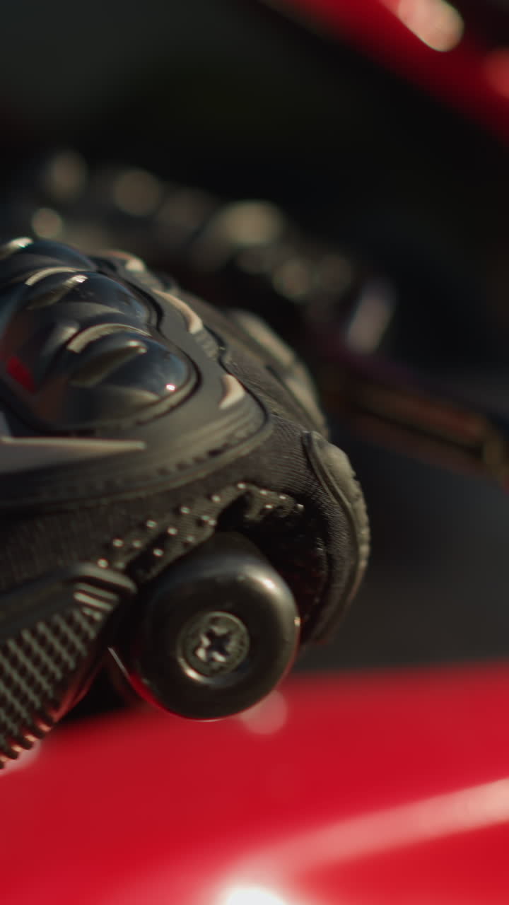 Close-up of a biker s hand wearing protective gloves, removing fingers from the clutch lever as the motorcycle moves forward and backward, a smartwatch is visible on the wrist