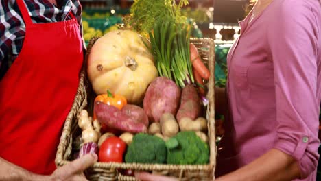 Personal-Masculino-Ayudando-A-Una-Mujer-A-Comprar-Verduras-En-La-Sección-Orgánica