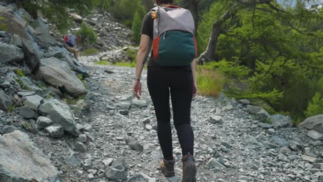 Chica-Mochilera-Caminando-Por-Un-Sendero-De-Montaña-En-Alpe-Ventina,-Italia---Amplia