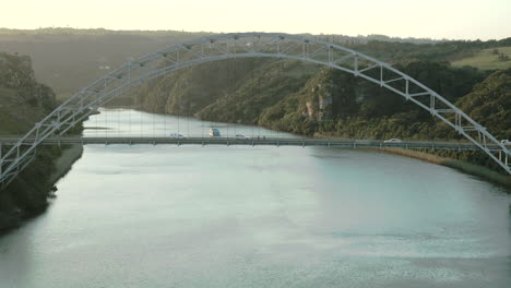 aerial fly over a suspension bridge across a river in south africa