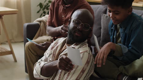 Black men and boy looking at pictures in the living room