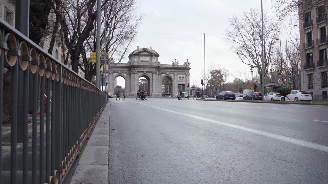 escena en la carretera en madrid, españa con la famosa puerta de alcala, una puerta neoclásica en la plaza de la independencia, en el fondo - tiro largo lateral