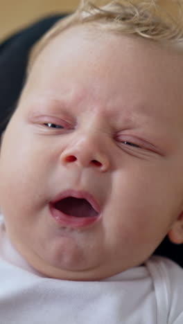 adorable tiny caucasian baby yawning sweetly. close up. mom's touches little kid's nose. vertical video