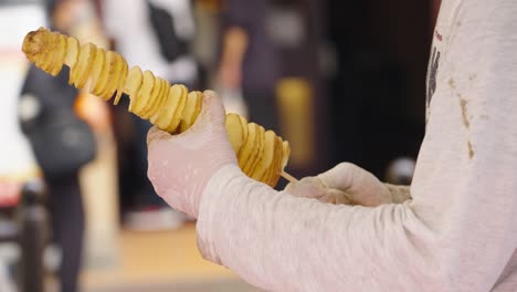 Street-vendor-preparing-Tornado-Potato-on-skewer---popular-street-food