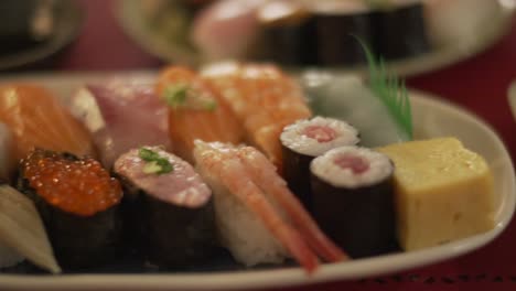 platos de delicioso sushi surtido servido en un restaurante de sushi en tokio, japón - primer plano, tiro de seguimiento