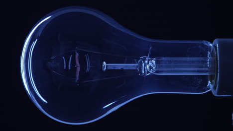 Clear-Incandescent-Lightbulb-Turning-On-Under-Blue-Ambient-Light