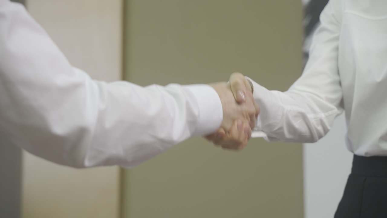 primer plano de un jefe irreconocible y un empleado dándose la mano en la oficina