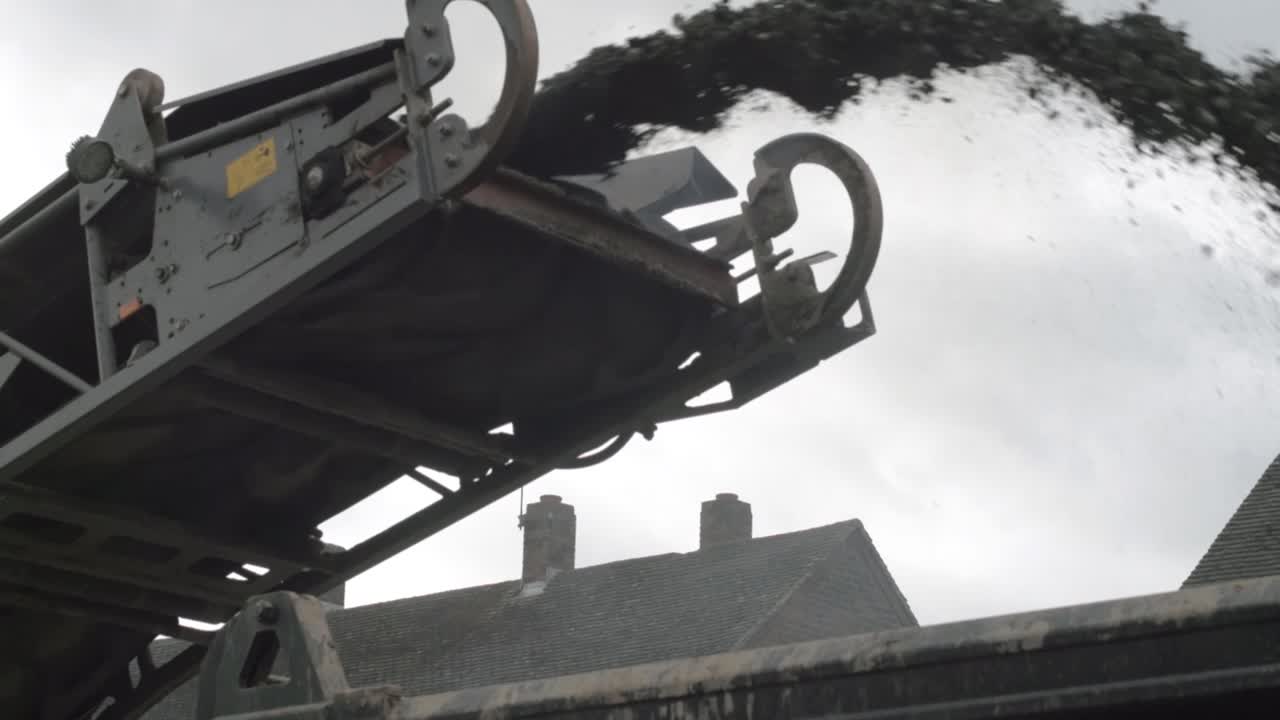 Heavy plant industrial milling machine loading asphalt onto truck