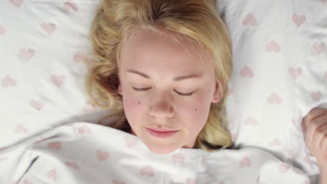 attractive young woman waking up in bed