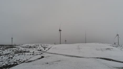 winter mountain countryside wind turbines on rural highlands aerial view cold snowy valley hillside lowering left