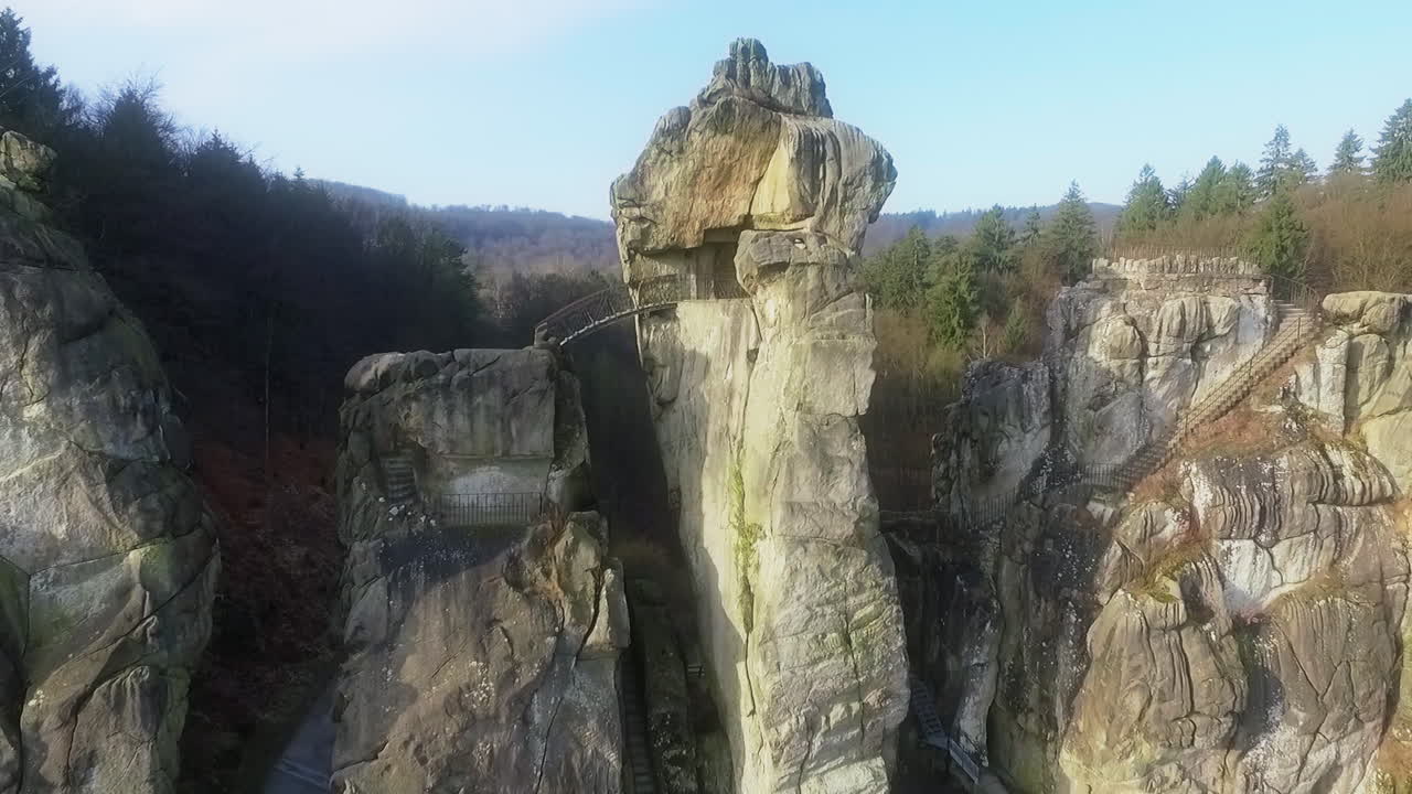 Droonin panoraamakuva Externsteine-kivimuodostelmista, joissa metsä ja kukkulat taustalla