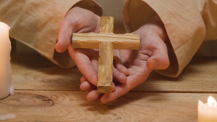 Close Up Shot Of Man Wearing Robes Representing Figure Of Jesus Christ Holding Wooden Cross 1