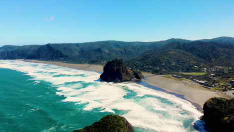 Aerial-Pull-Back-Piha-Beach,-Schwarzer-Sandstrand-Und-Vulkanische-Formationen,-In-Der-Nähe-Von-Auckland,-Neuseeland