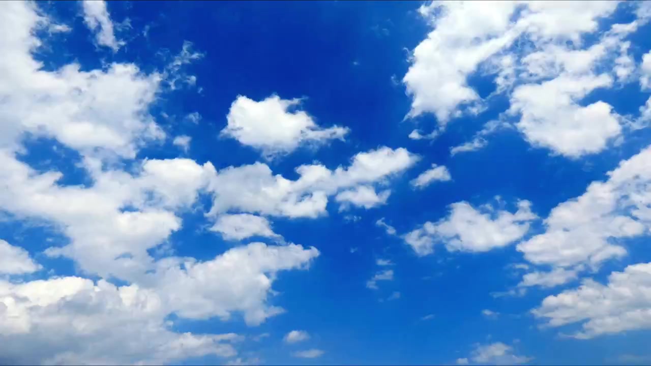 Timelapse de nubes a la deriva en un cielo azul brillante, mostrando el movimiento atmosférico natural y el cambio del clima en una escena exterior pacífica.