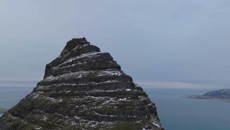 aerial view of rocky hill above coastline of iceland on cold winter day, drone shot