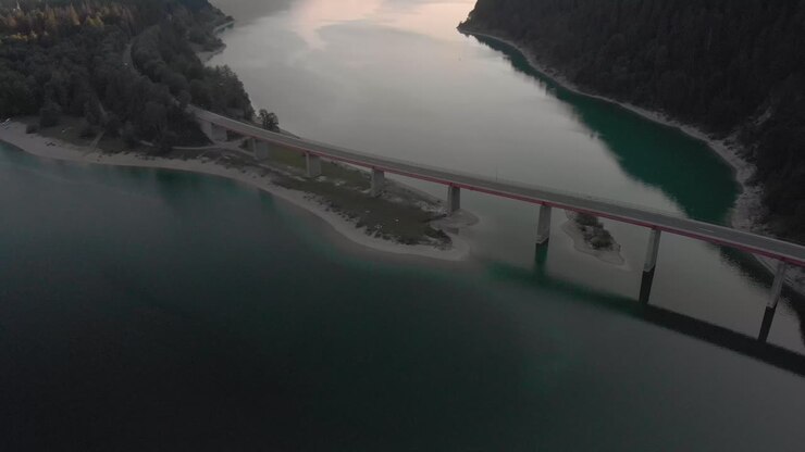una ripresa aerea dall'aspetto professionale delle alpi austriache, mentre il tramonto, rivelando un ponte