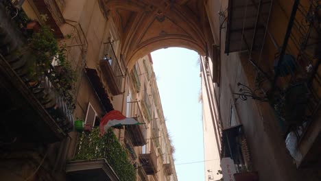 italian flag waving on a balcony, streets of naples, italy