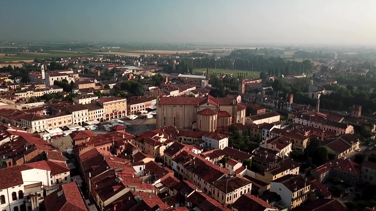 Uma tomada de drone circular sobre a cidade murada de Montagnana, no Vêneto, com a torre da igreja, muros medievais e telhados da cidade abaixo