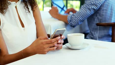 Woman-using-mobile-phone-while-having-coffee-4k