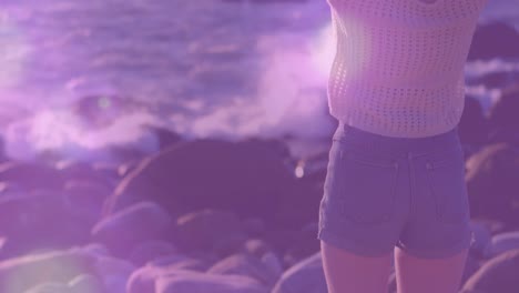 Animation-of-light-spots-over-caucasian-woman-at-beach