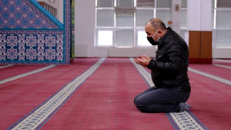 Masked-Man-Raising-His-Hands-And-Praying-In-Mosque