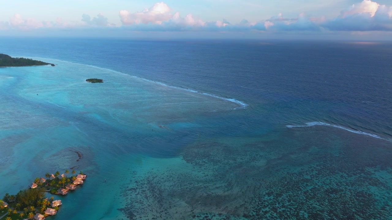 Morgen, øer, bungalow, Cooks Opunohu Bugt, Moorea, Fransk Polynesien. Luftdrone, Mount Mauaroa, Tohivea, Rotui, skyer, lagune, koralrev, bølger, levende grønblåt Stillehav, fremadgående panorering opad.