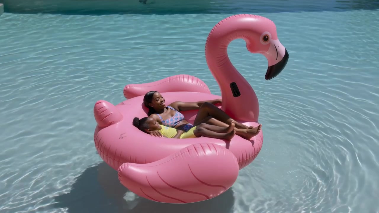 Floating on home pool current flamingo carrying teen in lavender suit child in yellow suit relaxing