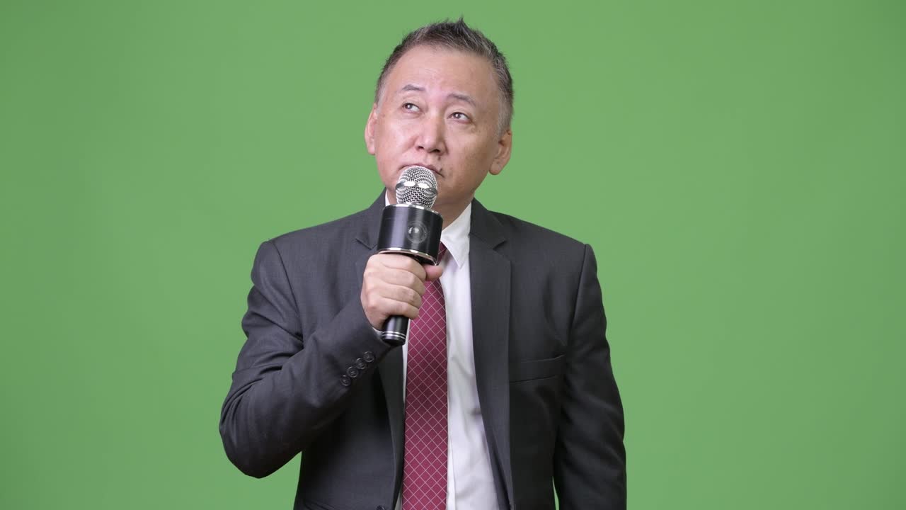 Mature Japanese businessman using microphone