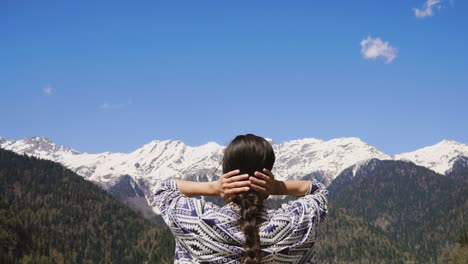 a young woman inhales clean and fresh mountain air in a nature reserve