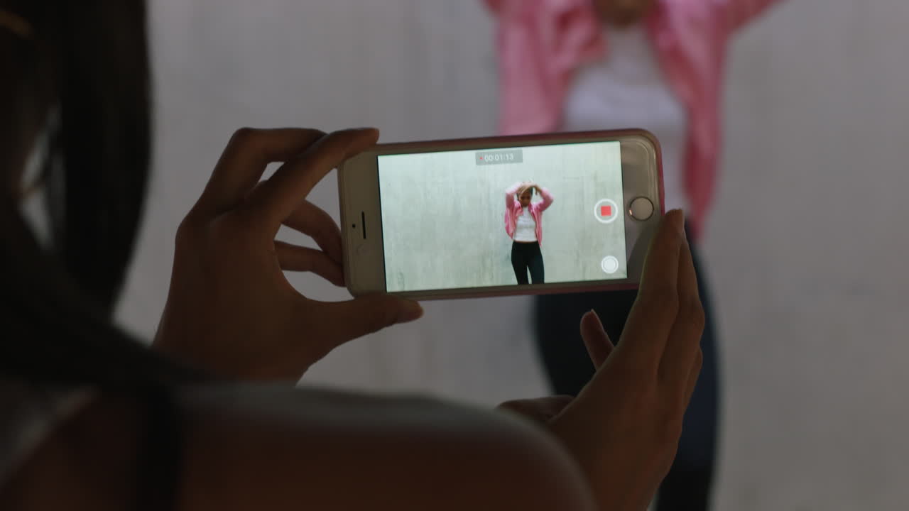 bailarina feliz bailarina de estilo libre amiga usando smartphone tomando video disfrutando de compartir el baile de hip hop en las redes sociales en un almacén urbano grungy