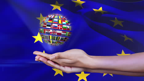 ball made of european nationals flags turning on hands in front of european flag