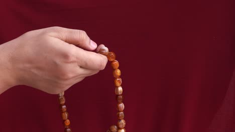 person holding prayer beads