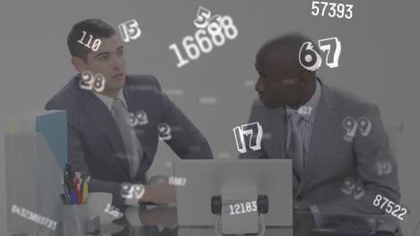 digital animation of multiple changing numbers and symbols against two businessman using laptop