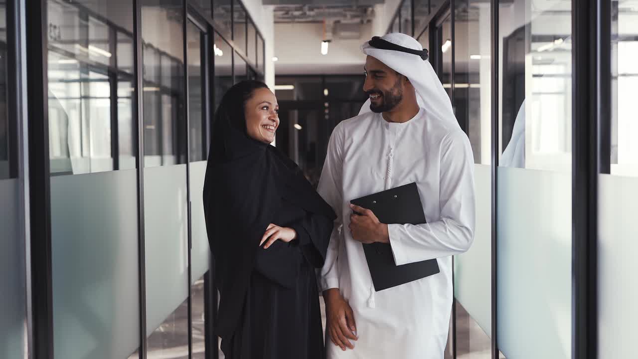 hombre y mujer guapos con ropa tradicional trabajando en una oficina de dubai