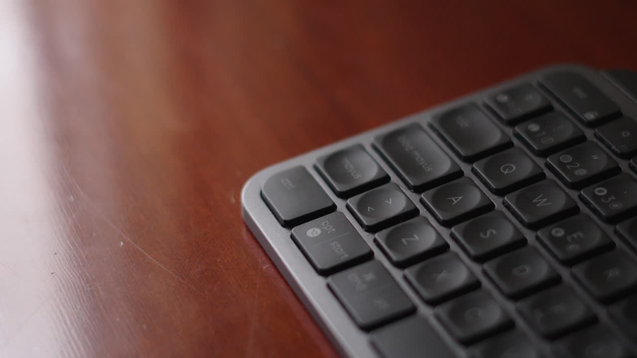 Dark Grey Keyboard Over A Glossy Wooden Desk Reflection Of A Window