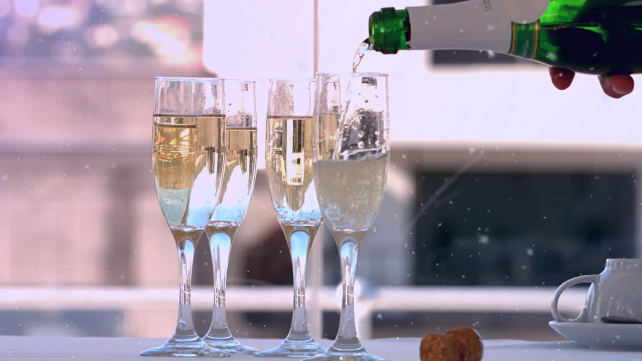 Animazione di neve che cade su bicchieri di champagne su un tavolo