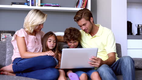 Familia-En-El-Sofá-Mirando-La-Computadora-Portátil