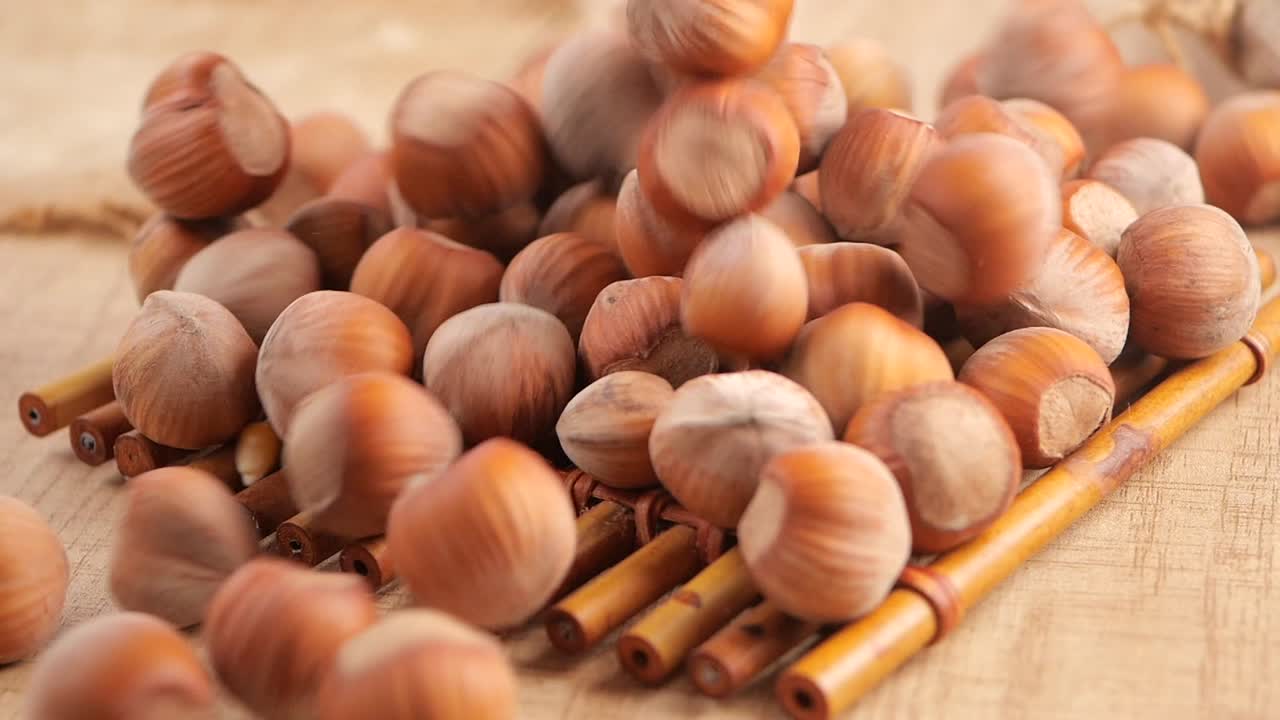Nocciole che cadono e si accumulano su una superficie di legno