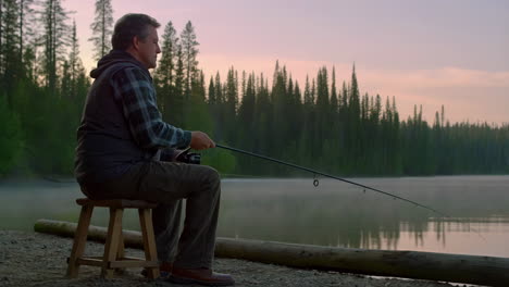 a man enjoying a peaceful fishing session by a lake at dawn or dusk
