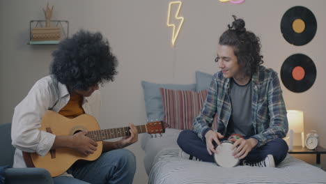 two teenagers playing music in bedroom