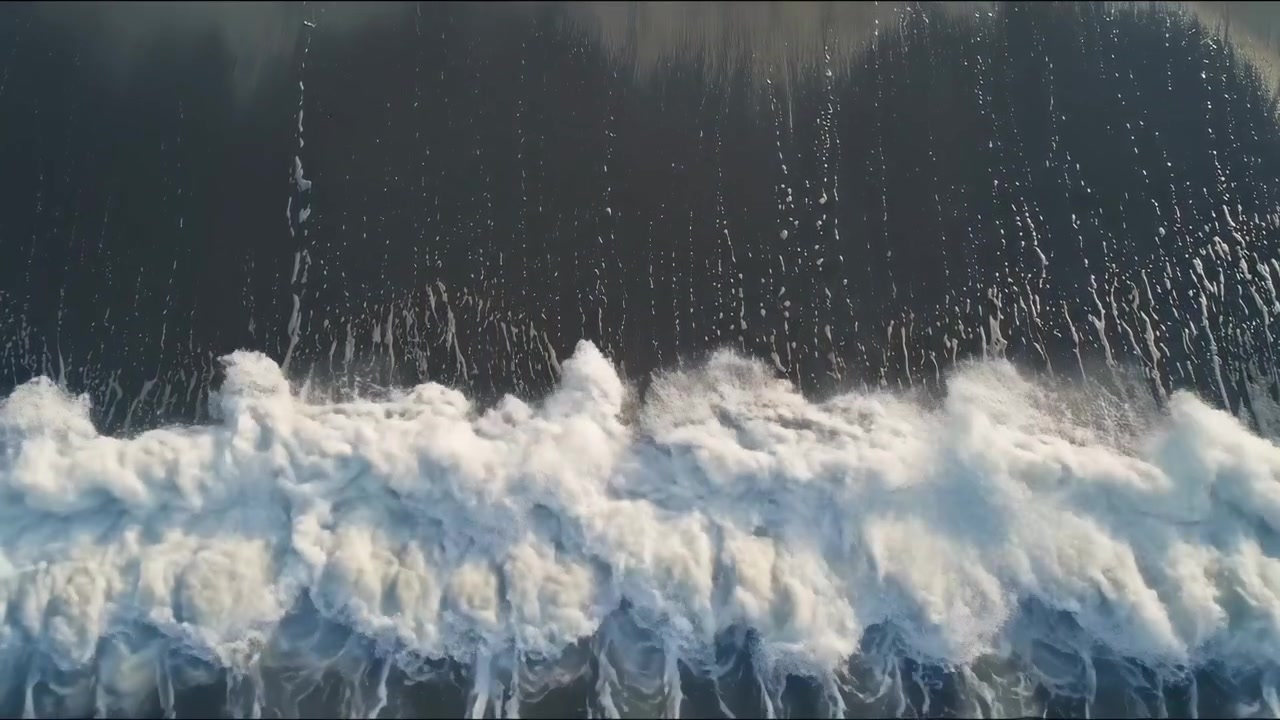 Luftfoto av Havbølger som Slår inn mot Sandstrand