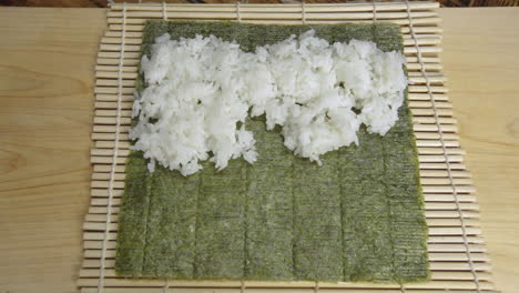 POV-Spreading-Rice-on-Seaweed-to-Make-Sushi-Rolls